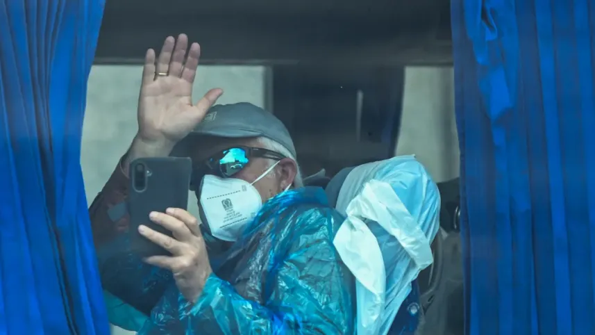 A passenger from the Dutch flagged hantavirus-stricken cruise ship MV Hondius waves aboard a military bus after being transferred by boat to the industrial port of Granadilla de Abona on the island of Tenerife in Spain's Canary Islands on May 10, 2026. Photo: AFP