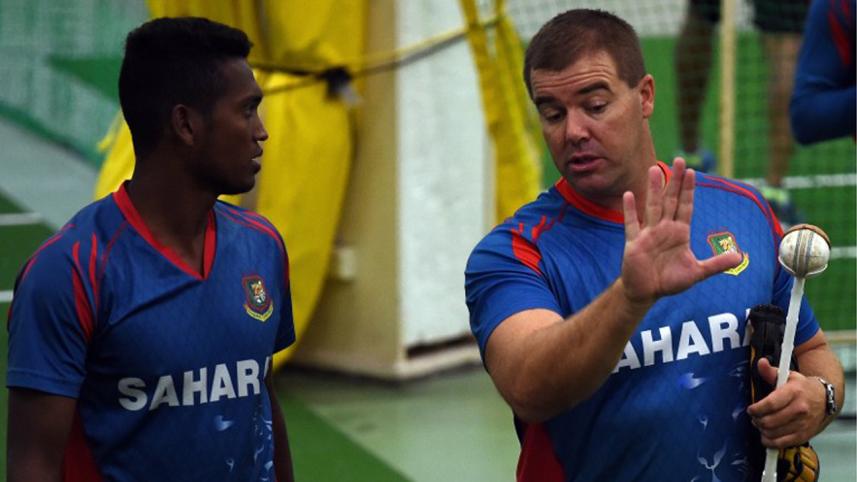 Bangladesh cricketer Al-Amin Hossain (L) listens to bowling coach Heath Streak during an indoor training session