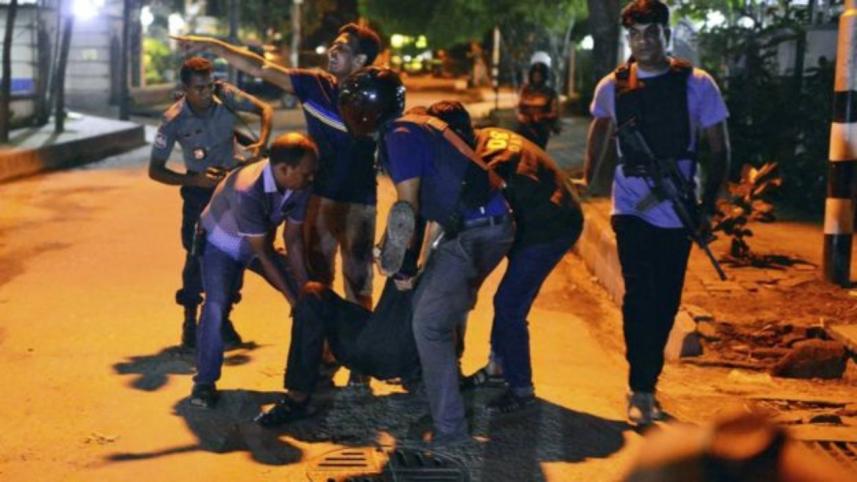 People help an injured person after gunmen attacked the Holey Artisan Café. 