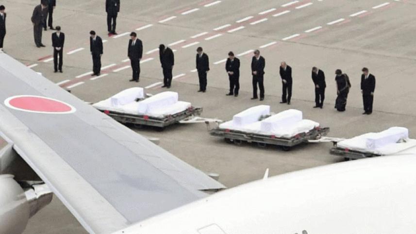 Government officials pray for the victims of Friday's Bangladesh terrorist attack after their bodies had arrived on a government plane at Tokyo's Haneda airport on July 5. Photo: The Japan Times.