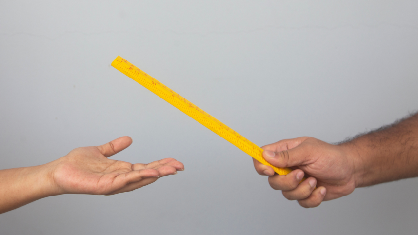 A teacher ready to hit their student's hand with a wooden scale