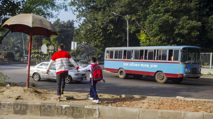 A father helping his son cross the steet.