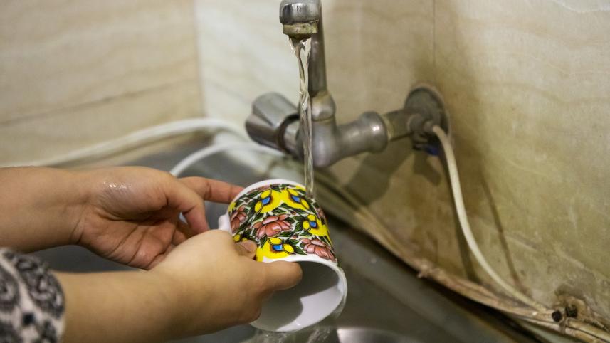 Person washing a mug.