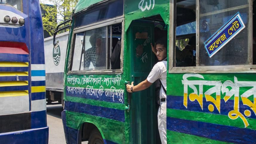 Student standing at the entrance of a bus.