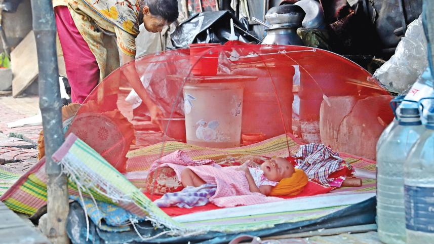 A baby sleeps inside a tiny mosquito net placed there by her homeless mother as a bite of an Aedes mosquito can cause dengue.