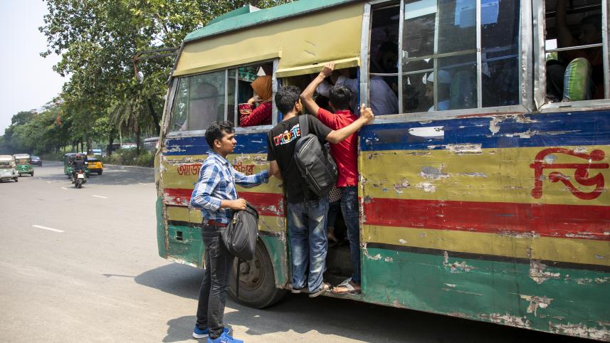 Student trying to get on a crowded bus. 