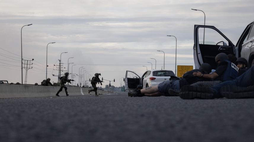 Journalists take cover as Israeli soldiers run to fight with Palestinian milton near Sderot on October 7, 2023.