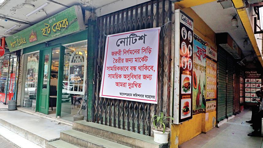 Putting up a notice saying the market is closed for construction of an emergency stairway, shopkeepers have blocked the entrance to Abedin Tower on Bailey road.