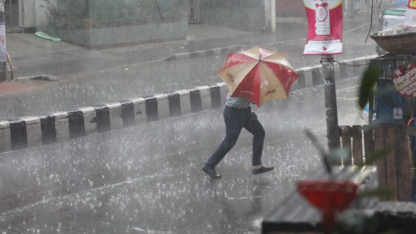 A pedestrian is crossing road holding an umbrella in Dhaka's Green Road. 