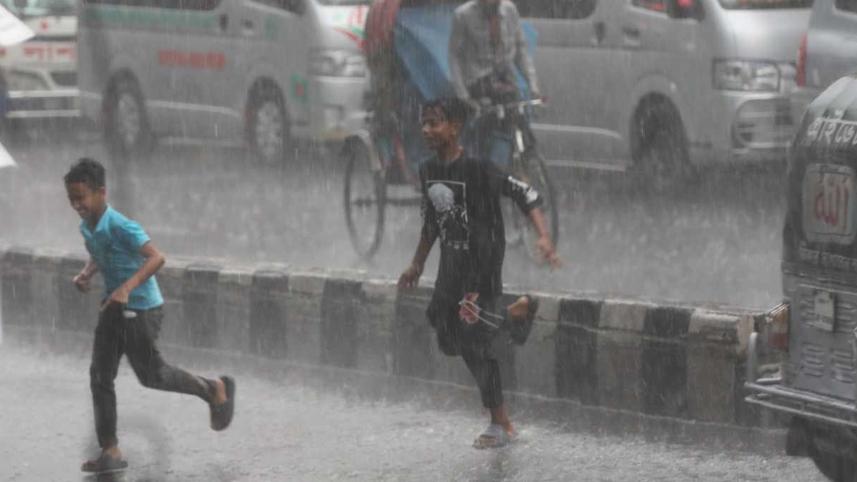Two children are crossing road amid rain in Dhaka's Green Road area.