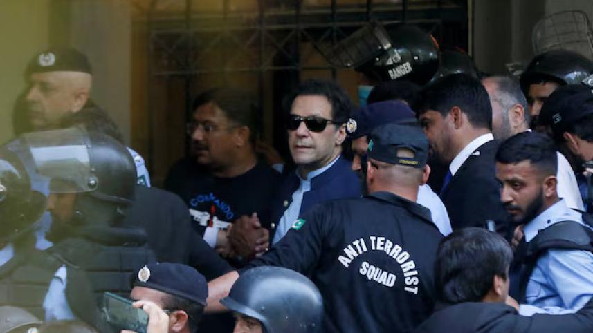 Security officers escort Pakistan's former Prime Minister Imran Khan, as he appeared in Islamabad High Court, Islamabad, Pakistan