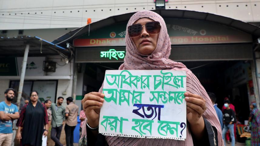 A parent holding a placard that reads, "Why would my children get killed for asking for their rights?" in front Dhaka Medical College Hospital entrance on July 30. PHOTO: PALASH KHAN