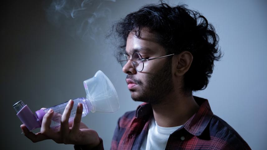 Person trying to use their asthma spacer.