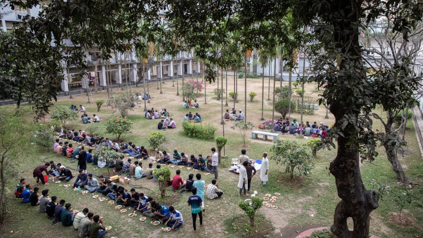 Groups of students having iftar together at their university dorm's courtyard. 