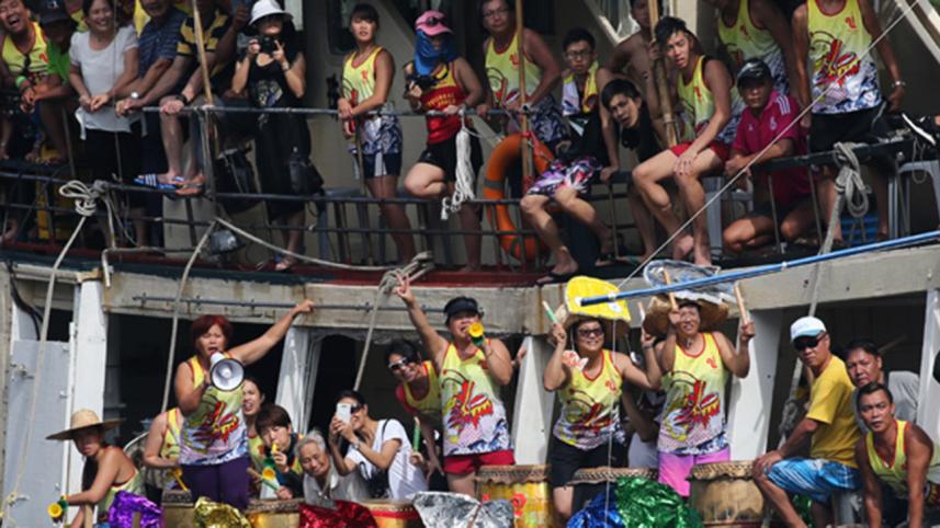 Fans play drums to support their team during the dragon boat race in Hong Kong, June 20, 2015.
