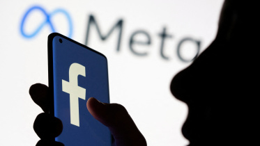 Woman holds smartphone with Facebook logo in front of a displayed logo for Meta in this illustration picture taken October 28, 2021. Photo: Reuters