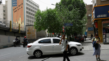People walk near an anti-US mural on a building in Tehran, Iran, May 19, 2026. Photo: Reuters