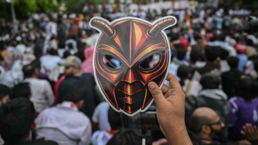 A Cockroach Janta Party (CJP) supporter holds a cockroach mask during a protest over alleged irregularities in the country's major examinations, in New Delhi on Saturday. Photo: AFP