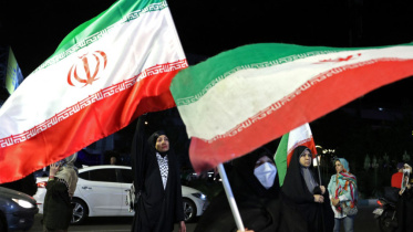 Women hold Iran's national flags during an anti-US and Israel protest at the Hafte Tir Square in Tehran on May 17, 2026. Photo: AFP