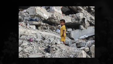 A Palestinian child stands on the rubble of a destroyed building near the Shati refugee camp in western Gaza City AFP (2).png