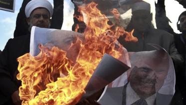 Palestinians burn posters