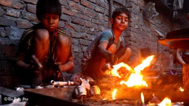 Ten-year old Shohag and his friend work close to open flames
