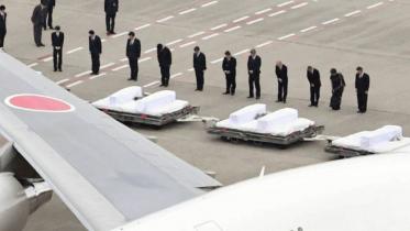 Government officials pray for the victims of Friday's Bangladesh terrorist attack after their bodies had arrived on a government plane at Tokyo's Haneda airport on July 5. Photo: The Japan Times.