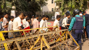 HSC examinees walking to the exam centre through police barricades set up due to political unrest