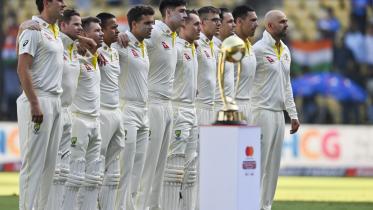 Australia's cricketers stand during national anthem