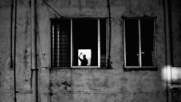 Man waving at his own reflection. 