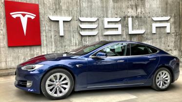 Tesla logo behind car