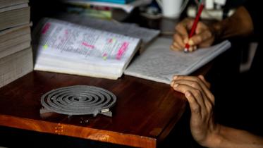 Student in their dorm room with a mosquito repellent coil burning.