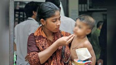 While waiting to see her arrested husband, Joly, 21, feeds her 18-month-old son in front of the CMM court yesterday afternoon.