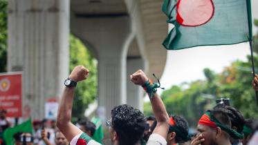 Student chanting with both their fists raised.  