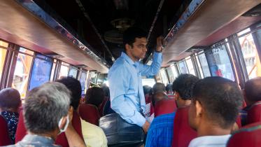 A student standing inside a bus.  