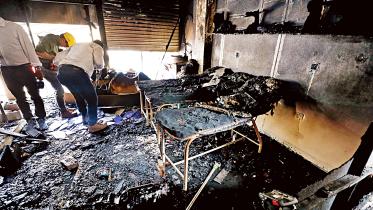 Firefighters inspect the charred debris inside a building in Gulshan’s Shahjadpur area