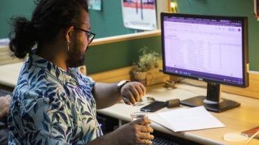 Young professional breaking their fast at their desk