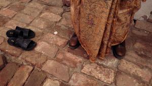 Person wearing a saree and a pair of boots with flats on the side. 