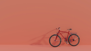 A red bicycle against a solid orange backdrop.  