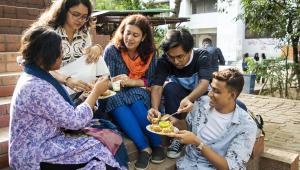 Students huddled together, enjoying a plate of fuchka. 