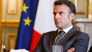 Macron sitting near French flag
